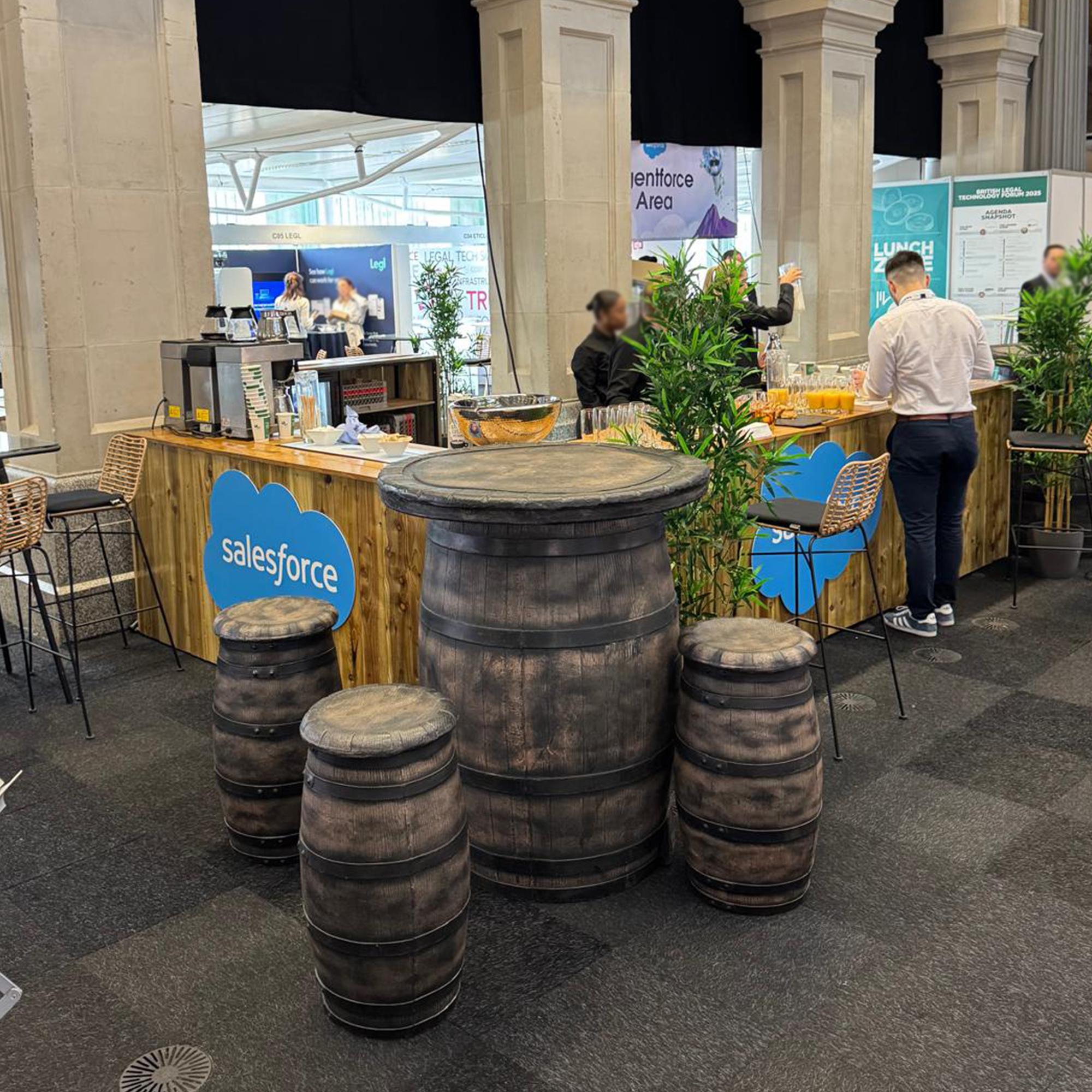 Rustic bar hire with barrel tables and matching stools.