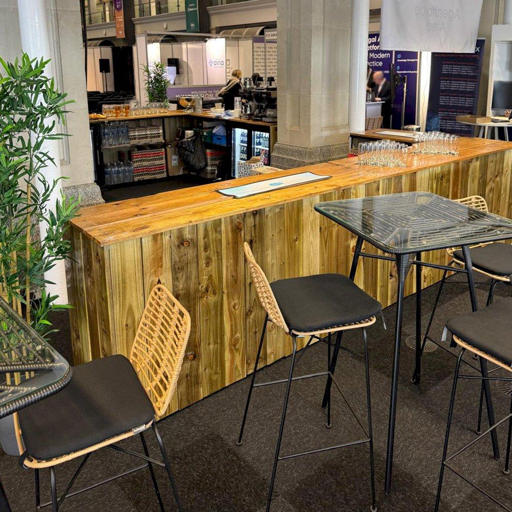 Create an outdoor vibe, inside, at your next trade show with our rustic bar hire and Miami poseur tables and matching stools.